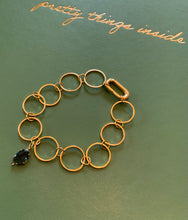 Load image into Gallery viewer, A gold filled circular connected bracelet with a sapphire blue crystal charm and a lever clasp.